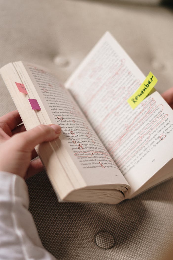 Close-up of a book with annotations and sticky notes with Remember.